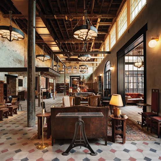 Brick brewery hall with iron columns and retained tanks converted to a hotel lounge