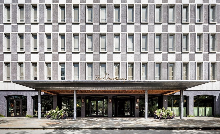 Flat mid-century office frontage in stone facing a city park