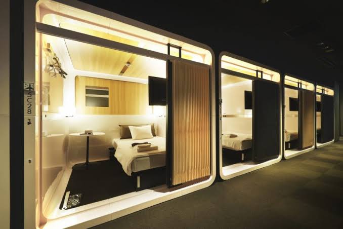 Row of screened sleeping cabins along a lit interior corridor