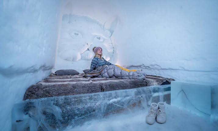 Corridor of packed snow with carved openings leading to sleeping chambers